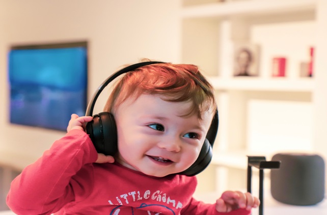 Uśmiechający się chłopiec w słuchawkach słuchający muzyki